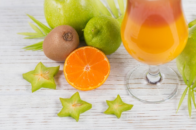 Cóctel de verano con varias frutas tropicales alrededor.