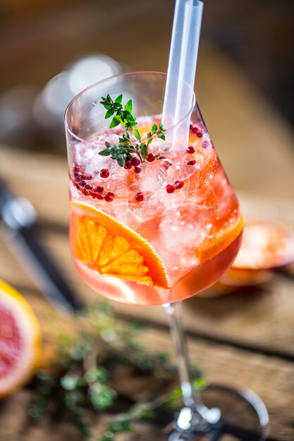 Cóctel en una vieja tabla de madera Bebida alcohólica con frutas tropicales, pimiento rojo y hierbas