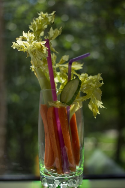 Foto coctel de zanahoria, apio y pepino en vaso, comida saludable, luz dura