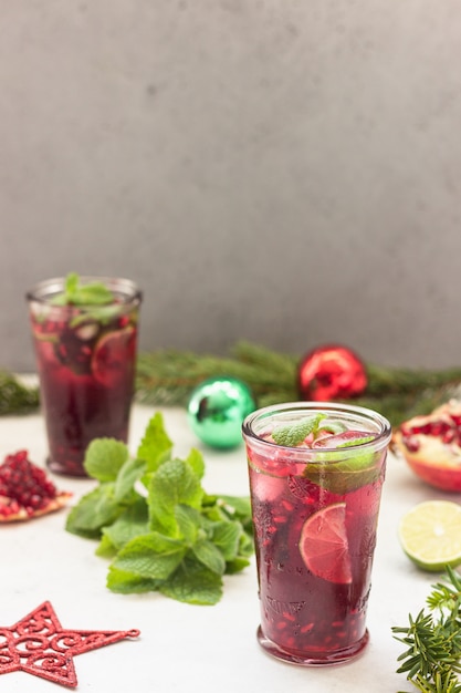 Cóctel con zumo de frutas, lima, menta, granada y hielo.