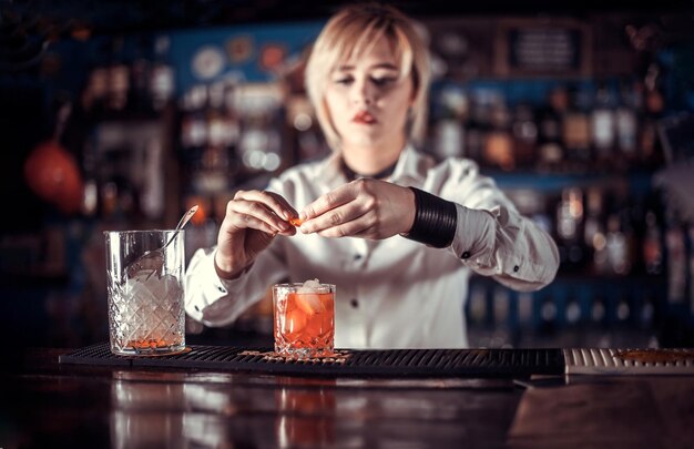 Foto una coctelera confiada formula un cóctel mientras está de pie cerca del mostrador del bar en la discoteca