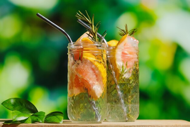 Cócteles de agua mineral con rodajas de pomelo y ramitas de romero