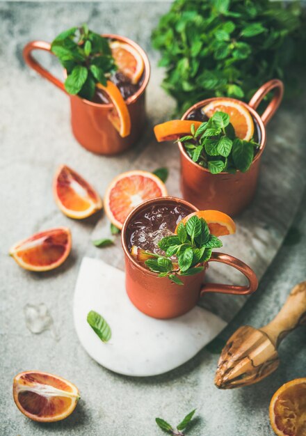 Cócteles de alcohol de mula de Moscú de naranja sanguina sobre fondo de hormigón