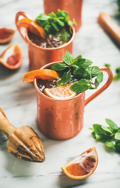 Cócteles de alcohol de mula de Moscú de naranja sanguina en tazas