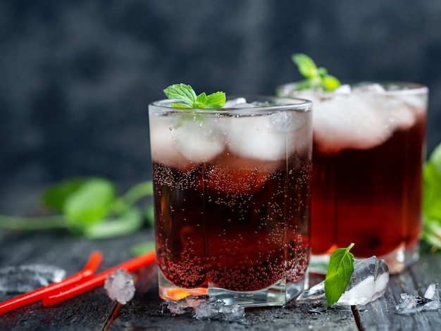 Cócteles alcohólicos de verano rojo con hielo y menta. Sin gaseosa y con gaseosa