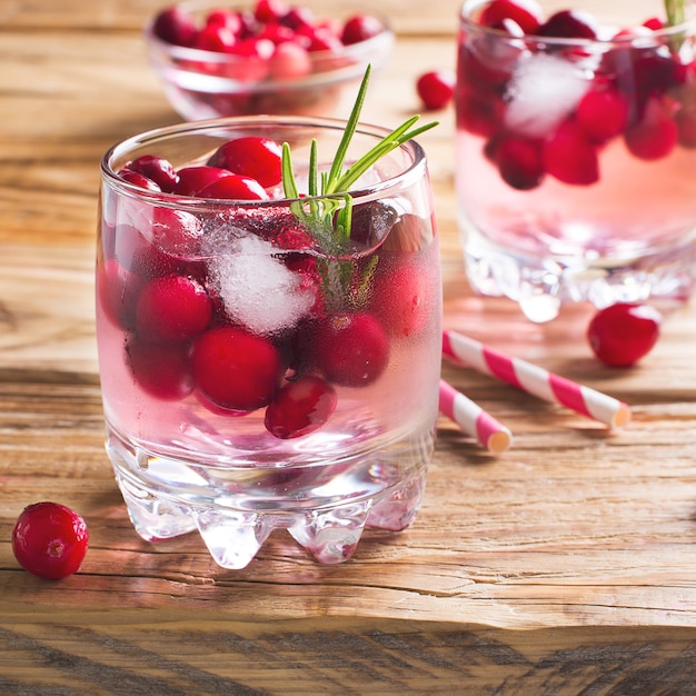 Cócteles de arándanos con bayas de hielo y romero