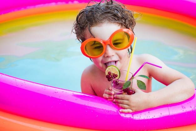 Cócteles bebidas Niños jugando y concepto de piscina de ocio activo Niños lindos relajados y bebiendo cócteles en la piscina