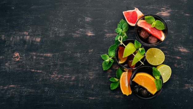 Cócteles con cítricos y menta Limón pomelo lima naranja Sobre un fondo de madera Vista superior