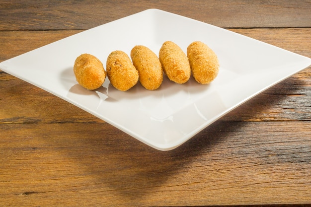 Codfish-Stückchen oder Kabeljau backt, ein traditioneller Aperitif in Portugal auf weißem Hintergrund zusammen