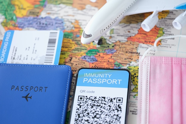 Código qr do passaporte da vacina da covid na tela do smartphone e avião com passagens digitais