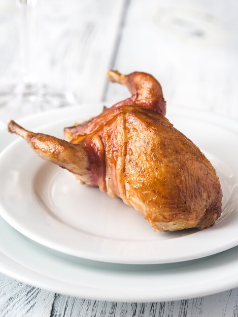 Foto codorniz al horno envuelta en tocino