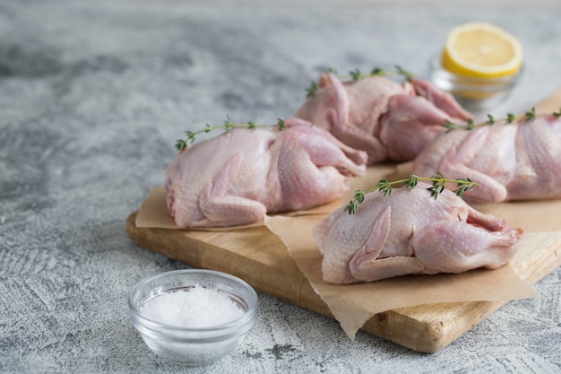 Codorniz cruda cruda. codornices de carne cruda listas para cocinar en una tabla de cortar con espacio de copia