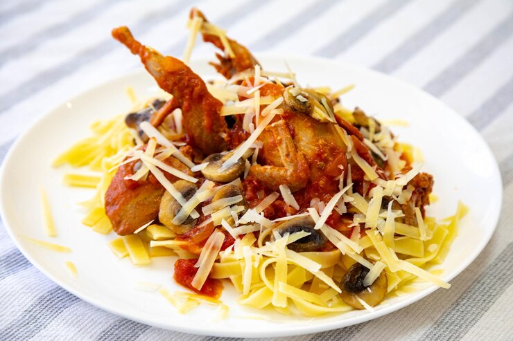 Foto codorniz preparada en un plato con pasta y migas de huevo