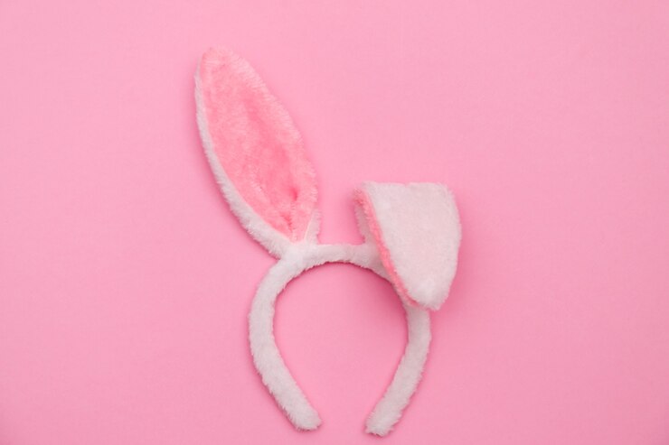 Foto coelhinho da páscoa. conceito de fundo do feriado de páscoa feliz. plano de colocar ovo de coelho colorido com acessório para celebração em papel pastel rosa rústico moderno na mesa de escritório em casa.