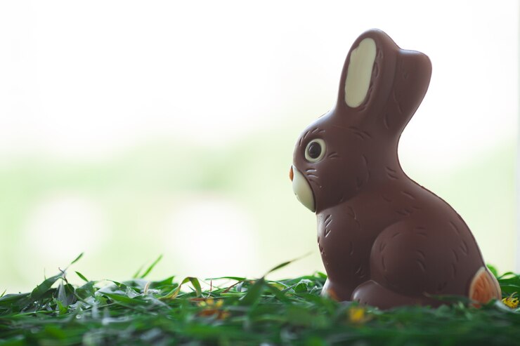 Coelhinho da Páscoa de chocolate num prado. Chocolate saboroso.