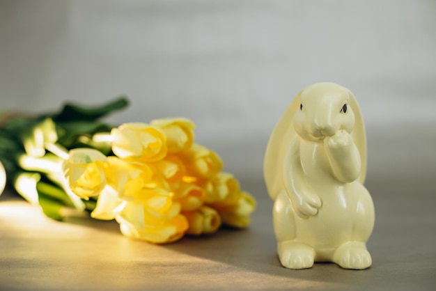 Coelhinho da páscoa de porcelana pelas tulipas