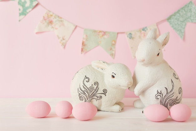 Coelhinhos da Páscoa com ovos pintados de rosa e guirlanda