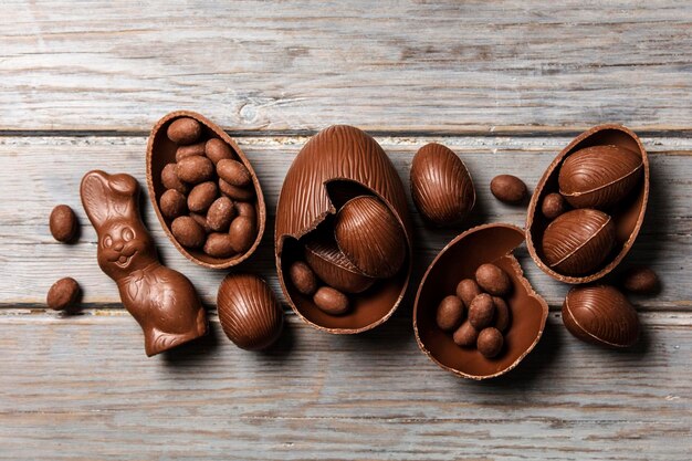 Coelhinhos da páscoa de chocolate e ovos em um fundo de madeira rústico