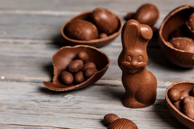 Coelhinhos da páscoa de chocolate e ovos em um fundo de madeira rústico