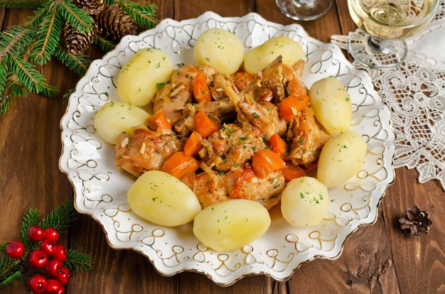 Coelho assado com ervas, legumes e molho de vinho branco. Este guisado de coelho é uma combinação saborosa de coelho picado, cenoura e batata.