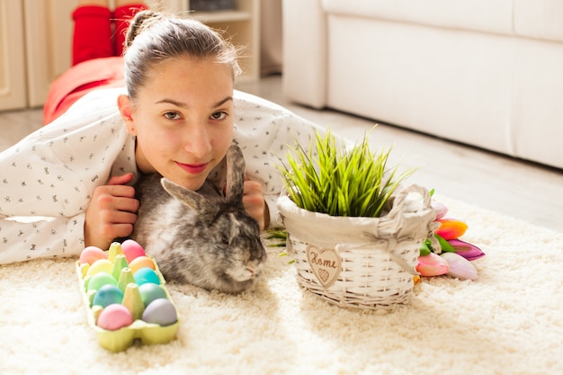 Coelho da páscoa em casa com ovos e grama verde