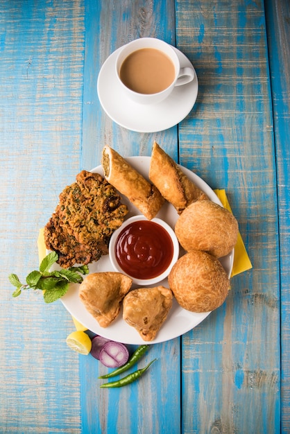 Coentro ou Kothimbir vada, Samosa, Kachori, Daal Vada são os petiscos favoritos da hora do chá na Índia. foco seletivo