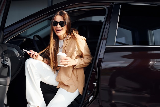 Coffee break Elegante bela jovem e seu automóvel moderno