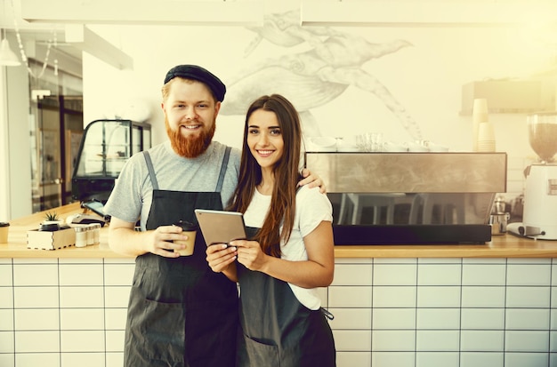 Coffee Business Concept Baristas alegres olhando para seus tablets para pedidos online