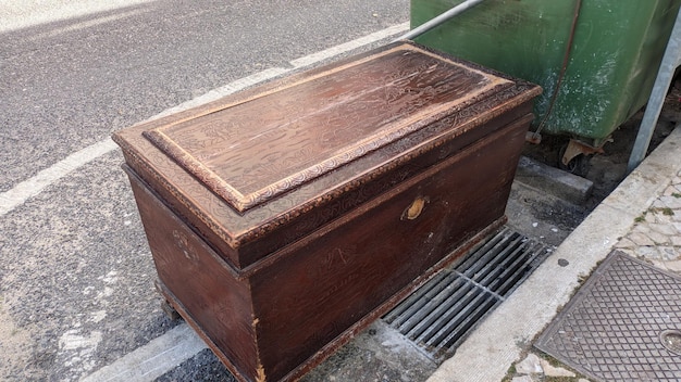 Un cofre viejo, una caja con tapa, fue arrojada a la calle cerca del contenedor de basura