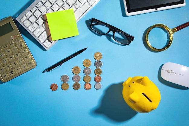 Cofrinho de calculadora de moedas e outros objetos na mesa de negócios