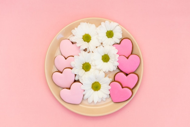 CoGinger cookie em forma de coração no fundo rosa pastel