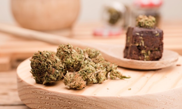 cogollos de cannabis muffins de cupcake de chocolate con cogollos de cannabisPastel de marihuana sobre una mesa de madera marrón