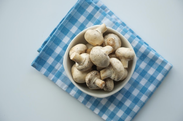 Cogumelo champignon fresco em uma tigela branca na mesa