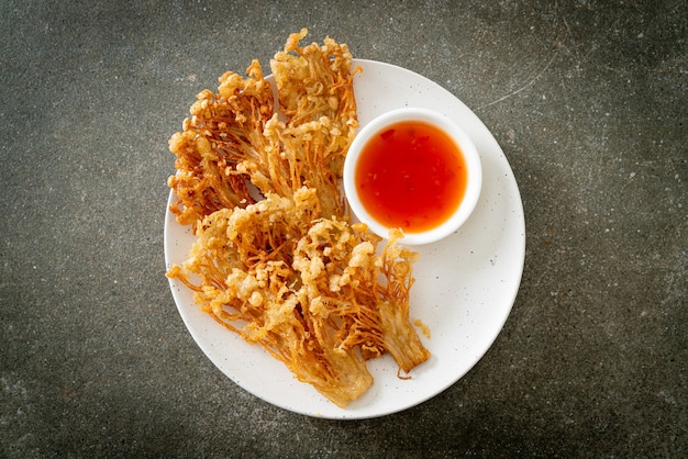 cogumelo enoki frito ou cogumelo de agulha dourada com molho picante - estilo de comida vegana