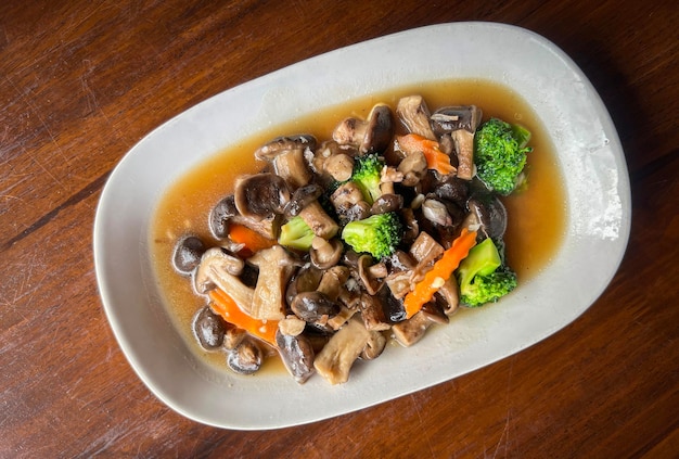 Cogumelo frito com brócolis cenoura vegetal cogumelos shiitake com molho de ostra cozinhar alimentos em prato branco cogumelo shiitake cozido por fritura