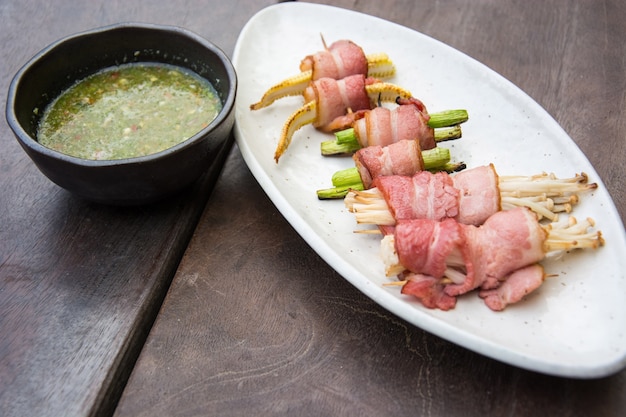 cogumelo grelhado de bacon com molho de frutos do mar na mesa de madeira desfoque suave e macio fo