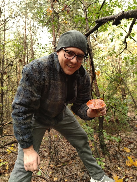 Foto cogumelo na mão de um homem cogumelos comestíveis floresta de outono colheita de cogumelos de outono mus da floresta