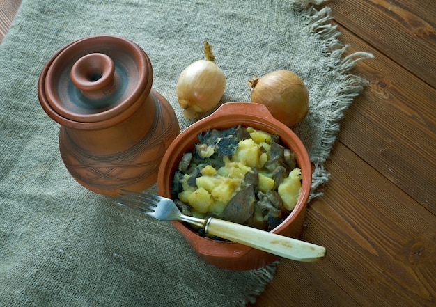 Cogumelo tushanka - guisado de batata bielorrusso em um fundo de madeira