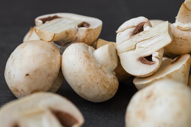 Cogumelos champignon frescos isolados em fundo escuro