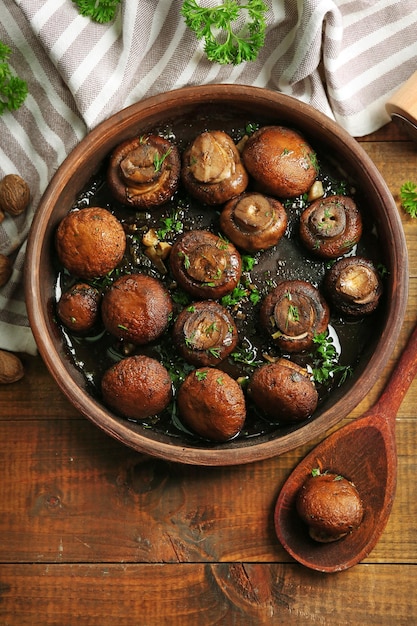 Cogumelos champignons assados com salsa manteiga e alho assado em tigela marrom