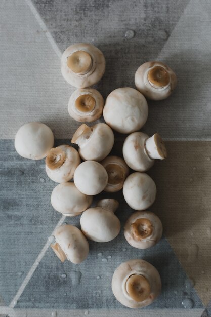 Cogumelos crus de cogumelos na mesa da cozinha vista de cima do fundo de alimentos
