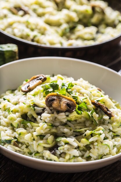 Cogumelos de abobrinha risoto italiano e parmesão em chapa branca.