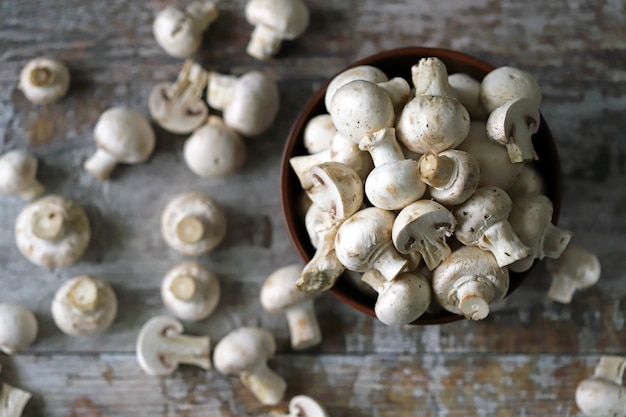 Cogumelos frescos champignon em uma tigela. Cogumelos crus. Foco seletivo.