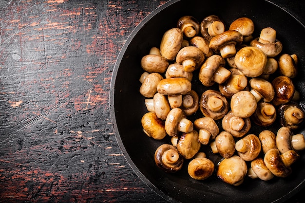 Cogumelos pequenos fritos em uma frigideira