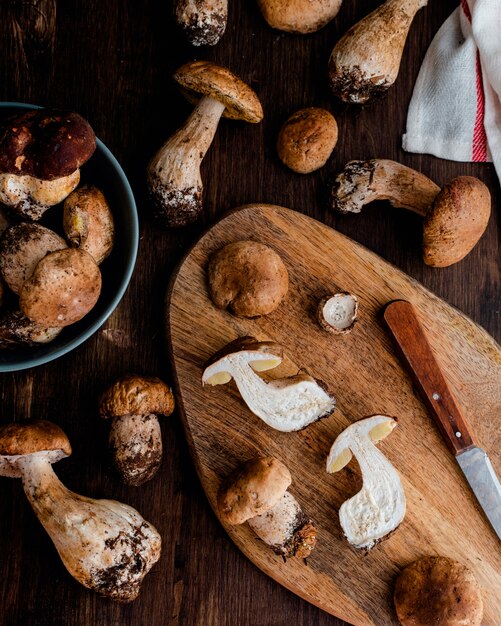 Cogumelos porcini comestíveis crus pão bun na mesa de madeira escura rústica