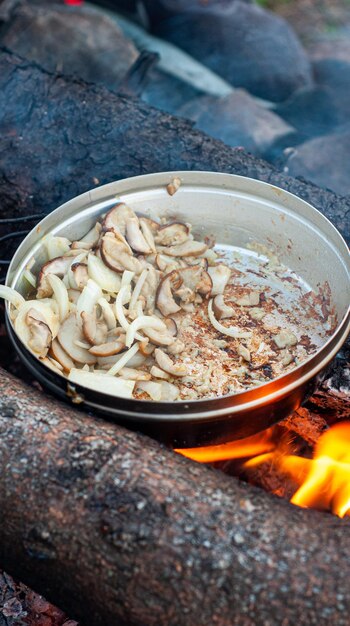 Cogumelos porcini são fritos em uma frigideira em uma fogueira comida ao ar livre camping férias deliciosas