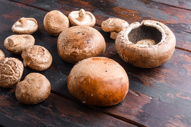 Cogumelos portobello e shiitake colocados na velha mesa de madeira