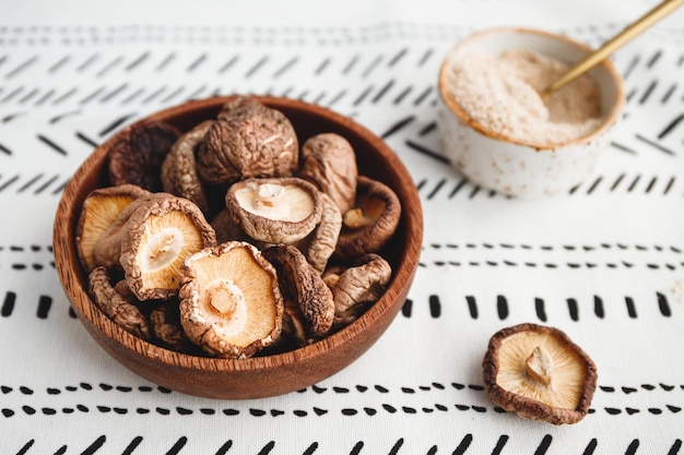 Cogumelos secos chineses Shiitake em uma tigela de madeira sobre uma mesa O conceito de superalimentos medicinais para a saúde Vista superior plana