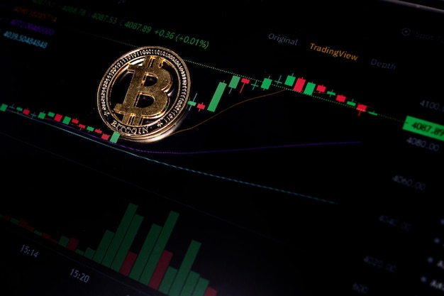 Coin Bitcoin auf dem Hintergrund-Kryptowährungs-Handelsdiagramm auf dem Computerbildschirm. Digitales Geld, Banking, Investitionen, Finanzen und Geschäftskonzept.