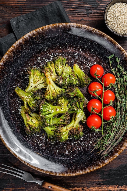 Col de brócoli asado a la parrilla con hierbas en un plato Fondo de madera Vista superior